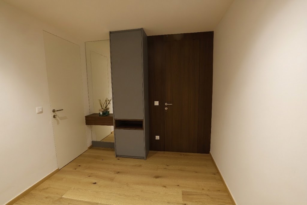 Flush white and dark wood concealed interior doors with matching wall paneling