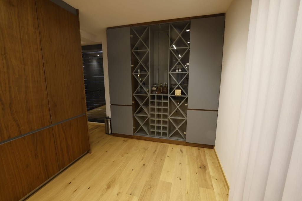 Custom built-in wine display cabinet with dark wood wall panels