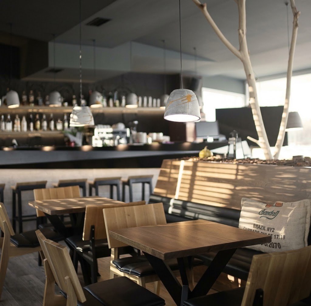 Cafe interior with solid wood tables, a dark bar counter and concrete pendant lamps