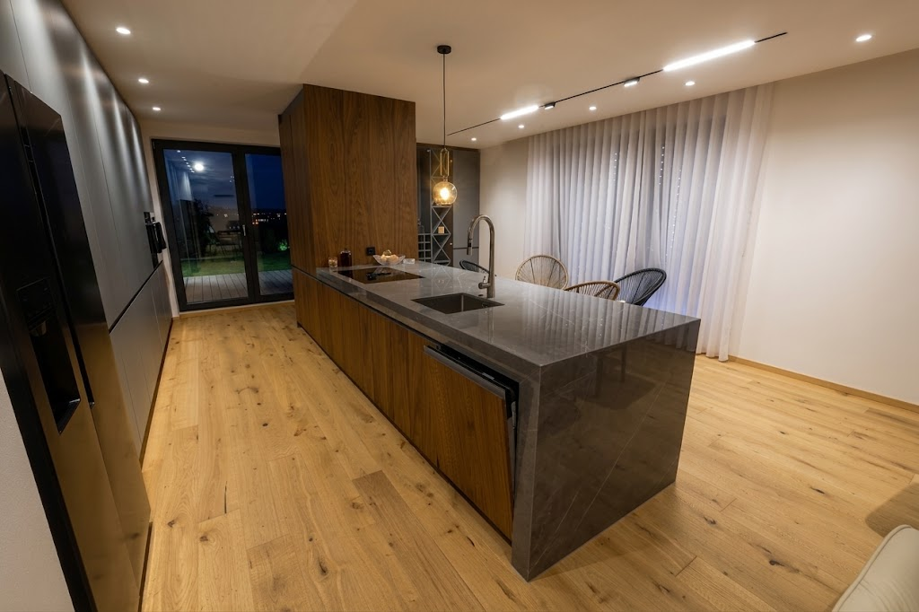 Dark luxury wood-front kitchen island with polished dark stone waterfall countertop